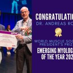 Dr. Andreas Roos receiving award on WMS 2023 stage, with text reading Congratulaions Dr. Andreas Roos, WMS President's Prize for Emerging Myologist of the Year 2023.