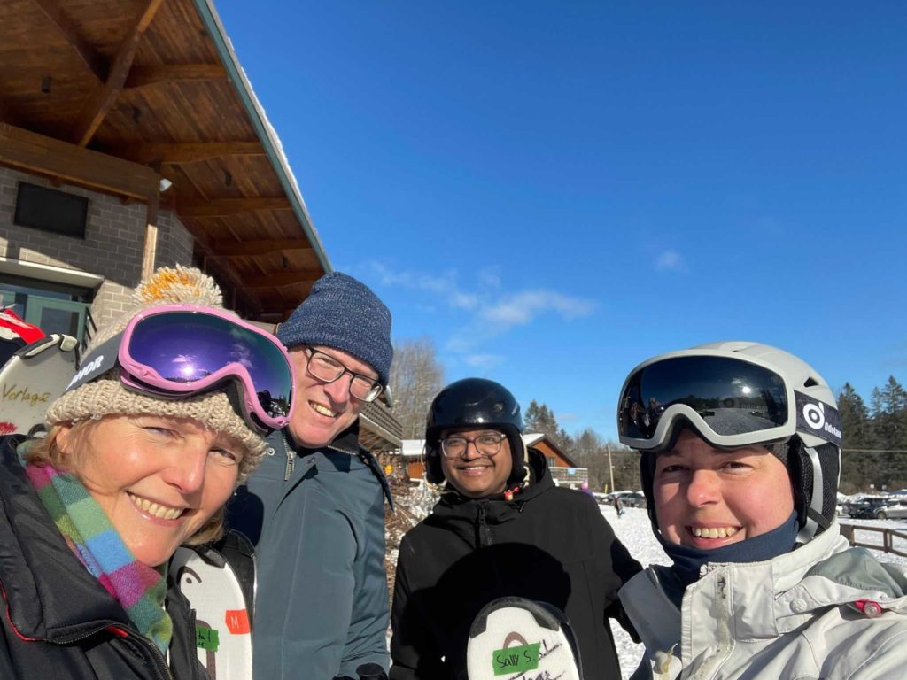Four lab members gathered for a selfie, with ski equipment.