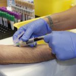 Healthcare professional taking a blood sample from an arm