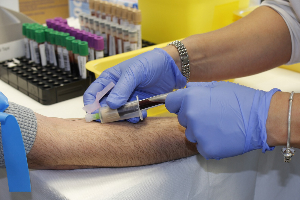 Healthcare professional taking a blood sample from an arm