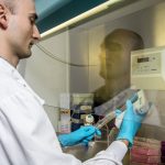 Researcher using a pipette in a fume hood